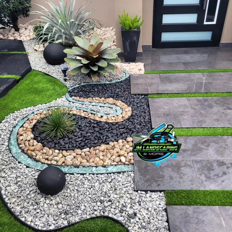 Río de piedras de colores con esferas negras y plantas ornamentales